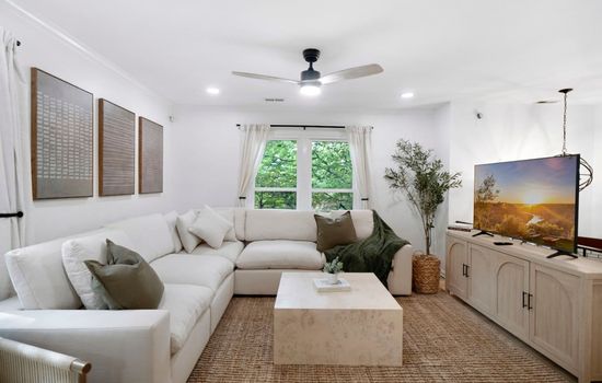 Bright living room w/ cozy seating, natural light, and warm accents—an easy spot to relax after a full day out.