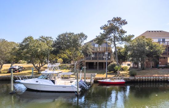 Waterfront neighborhood view w/ docks & boats, capturing the relaxed coastal setting.