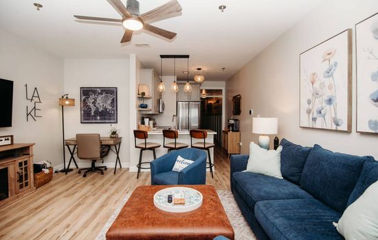Cozy & Modern Lake Retreat: Spacious living room with comfortable seating, stylish decor, and a fully equipped kitchen—perfect for relaxing after a day by the lake!

