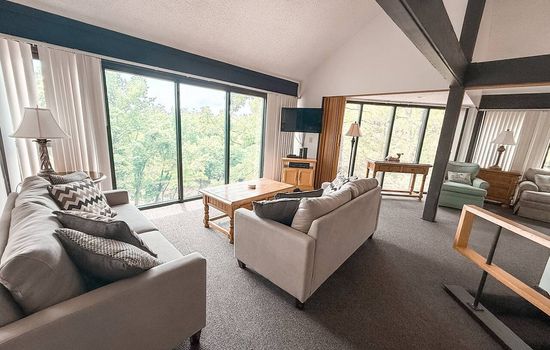 Unit 52s living room offers comfort and style with a wooded view just outside your window.
