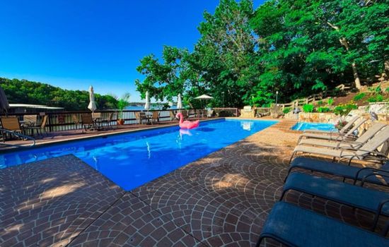 Relax by the sparkling pool at Treetop Village, complete with fun floats and a picturesque waterfall feature, creating a resort-like atmosphere.