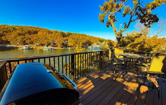 Private deck overlooking the lake — complete with BBQ grill and outdoor seating for dining with a view.