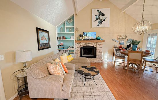 Relax in a bright, open-concept living space with cozy seating, stylish décor, and a warm fireplace.