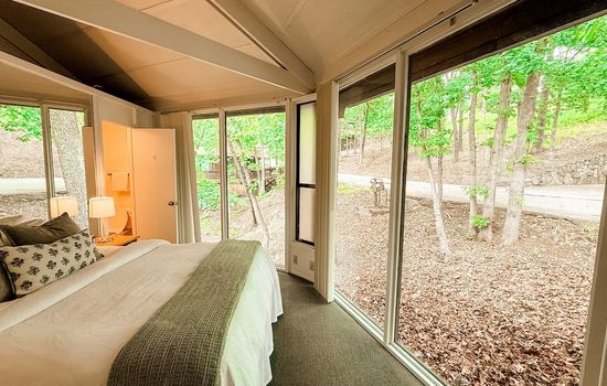 Comfortable bedroom showcasing the unique interior design and a spiral staircase adding character to this Treetop Village unit.