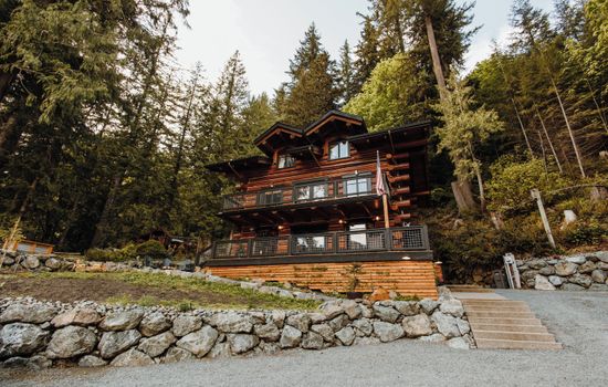 A grand three-story log cabin, seen from the street.