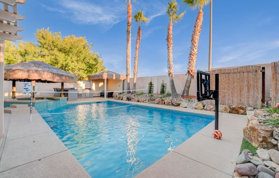 Private heated pool with palm trees, lounge seating— perfect for relaxing Las Vegas days