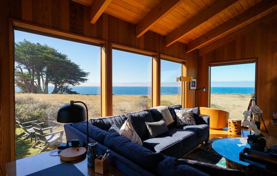 "The view from the living room was amazing- a cypress tree and the ocean with sufficient privacy from those walking by the ocean."  Views reveal an inspiring coastal panorama through expansive windows  in a serene, light-filled living space. 
