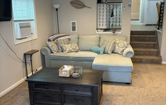 Unwind in the cozy living space with a coastal modern touch. Sink into the comfortable seating, and enjoy how the open layout flows seamlessly into the kitchen and sleeping area, making it an inviting spot to gather, recharge, and feel at home.
