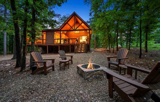 View of the spacious back porch, softly lit for a peaceful setting—perfect for unwinding in this cozy cabin