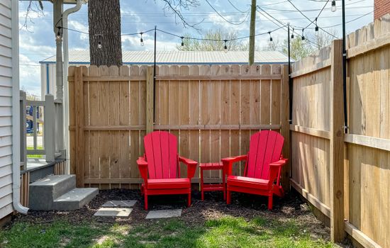 Fenced side yard with seating and twinkle lights