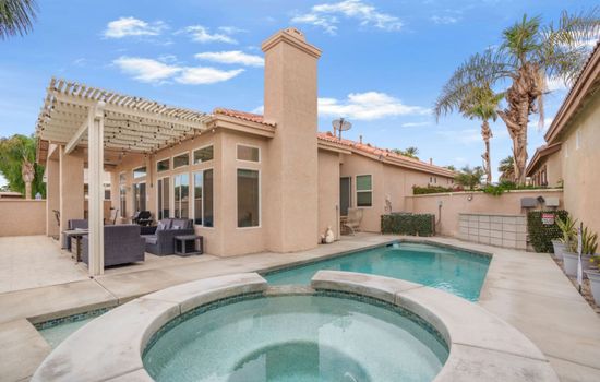 Private backyard pool w/ lounge seating and tall palms creating a relaxed desert escape.