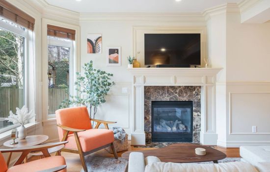 The living room has a marble fireplace, flat-screen TV, mid-century modern seating, and beautiful hardwood floors