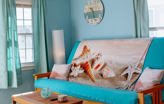 a view of the living room, complete w/queen size pull down futon couch & coffee table. This room has an air conditioner in the window during the on-season.