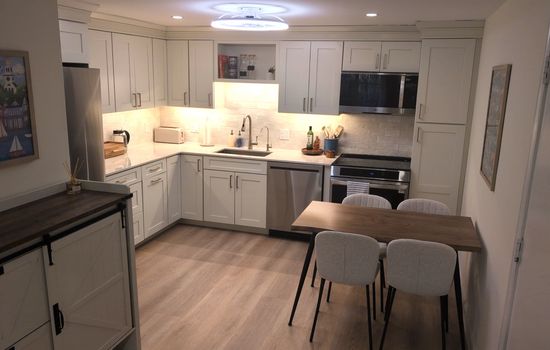 Kitchen with 4 top table, brand new stainless steel appliances, coffee maker.