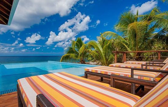 Our infinity edge pool creates a seamless horizon where crystal water meets the deep blue sea. It’s the ultimate spot to soak in the sun while the Caribbean feels close enough to touch. 🌊✨