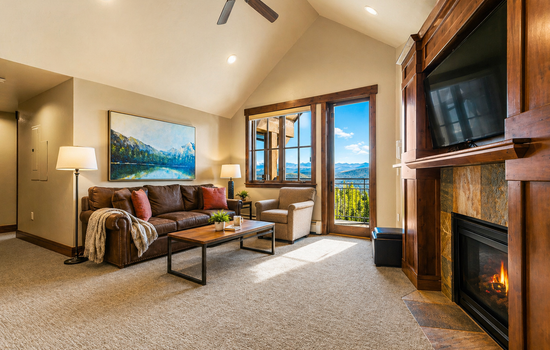 Bright living room with private balcony & fireplace.