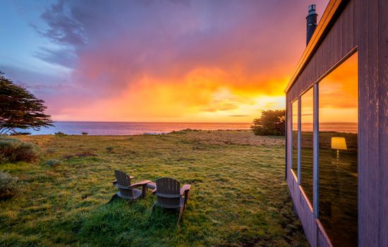 "The home is positioned to enjoy both sunrise and sunset views." Adirondack chairs face the Pacific, where evening light and color reflect  the quiet transition from day to dusk.