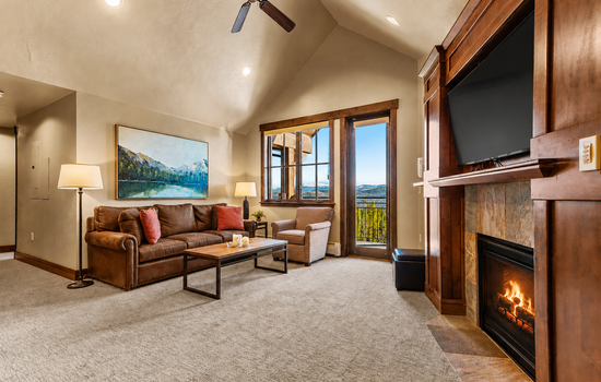 Bright living room with private balcony & fireplace.