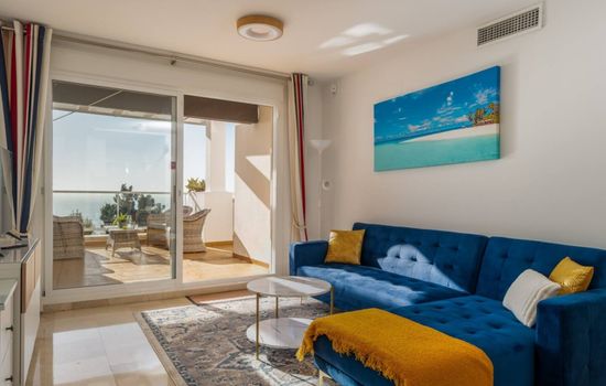 The living room opens directly to a sunlit private balcony with stunning sea views — perfect for blending indoor comfort with outdoor relaxation