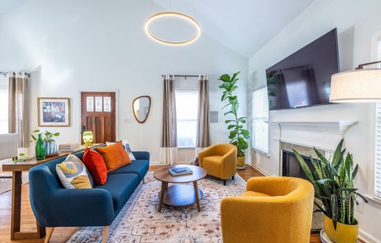 Start your morning with coffee and sunshine in this bright, airy living room filled with bold color and mid-century charm.