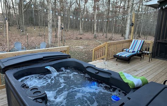 Soak in the bubbling hot tub on the large back porch, surrounded by a wooded, private setting—the perfect place to unwind, listen to nature, and relax under the stars.