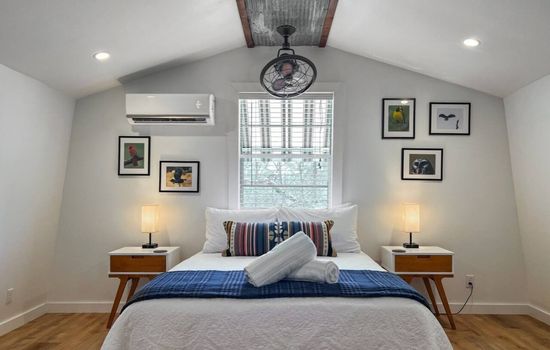 Sleep upstairs in a private-feeling suite with natural light and wooded views.