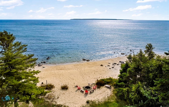 Aerial view of the beach and Mackinac Island in the distance.