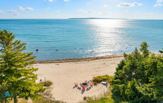 Aerial view of the beach and Mackinac Island in the distance.