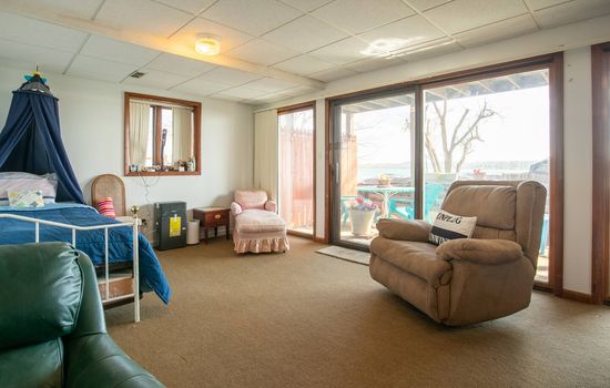 This room shows the canopy bed which is now a queen and the trundle bed is to the right of the brown chair