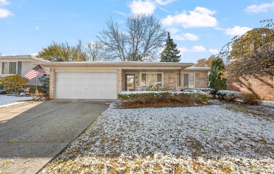 A welcoming front exterior with a clean driveway and bright natural surroundings.