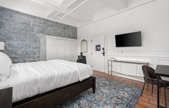 This is the private room you will be renting offering a bright space with a king bed, work area, and mounted TV.