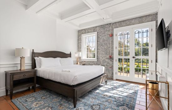 A bright private bedroom with a comfortable bed and soft natural light filling the space.