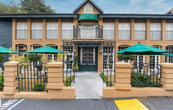 An elegant facade featuring tall windows, classic architecture, and thoughtfully maintained gardens.