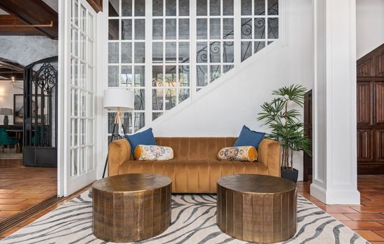 A stylish shared lounge by the staircase with plush seating and soft lighting located in the hotel’s common space and not inside your private room.