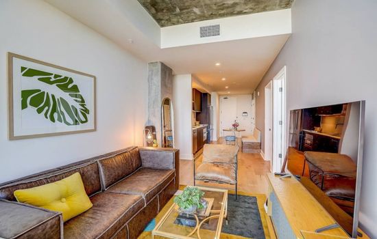 A spacious living room flooded with natural light through a grand, expansive window