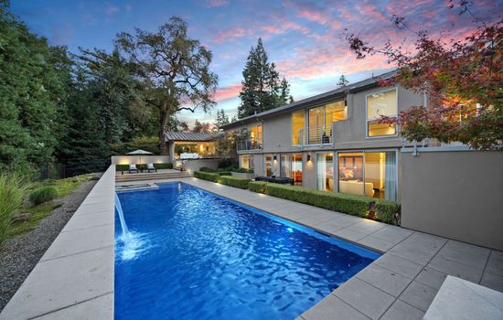 Resort style pool surrounded by beautifully landscaped grounds and elegant outdoor living spaces.