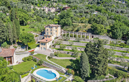 A photo from above of the lemon house complex with the swimming pool, large green spaces and olive trees. 