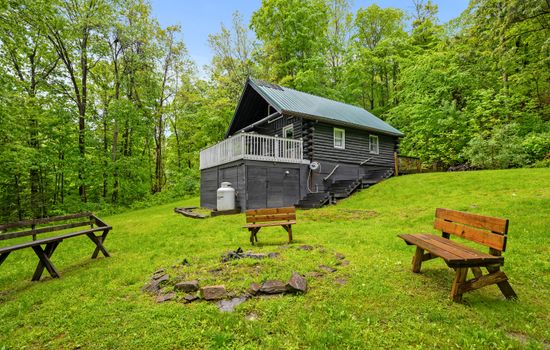 Log cabin exterior with stone fire pit