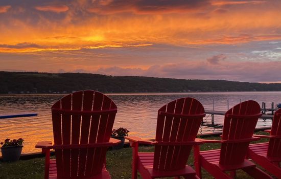 Adirondack chairs facing the sunset