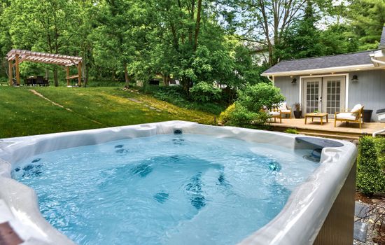 Hot tub beside stone path and patio seating